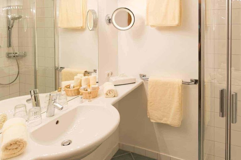 Modernes Badezimmer mit Dusche, Waschbecken und Pflegeprodukten im Hotel Erlhof.