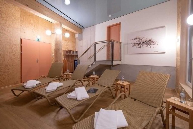 Entspannungsbereich im Hotel Erlhof mit Liegen und stilvollem Holz-Interieur.